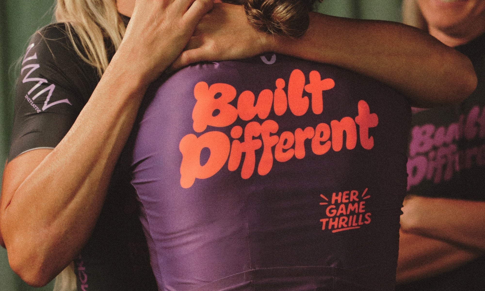 Three women cyclists embracing and smiling together